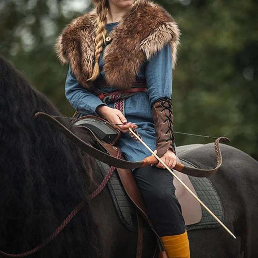 Viking Valkyrie archer sitting on horse, wielding a bow and arrow and wearing a brown laced bracer.